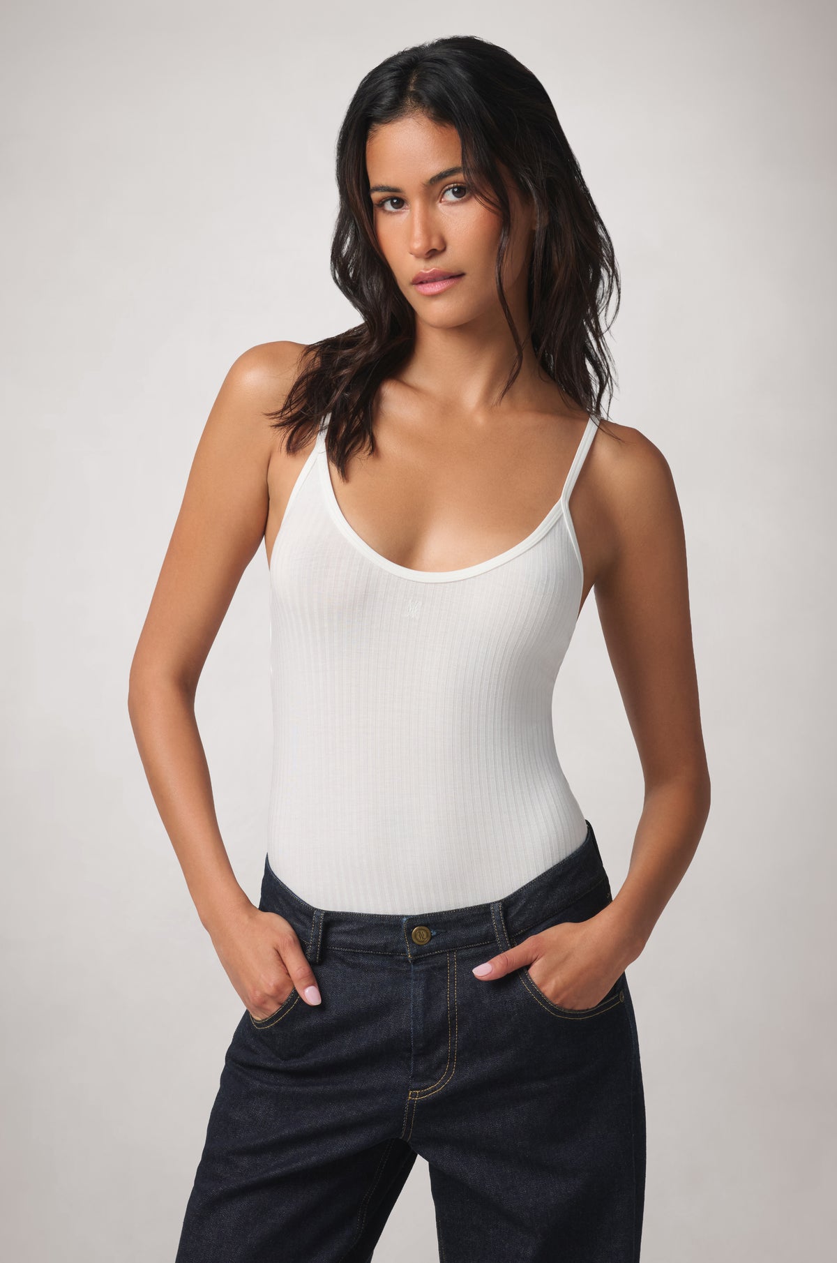 Kiki de Montparnasse Le Boy Bodysuit in white stretch rib knit with jean, front.