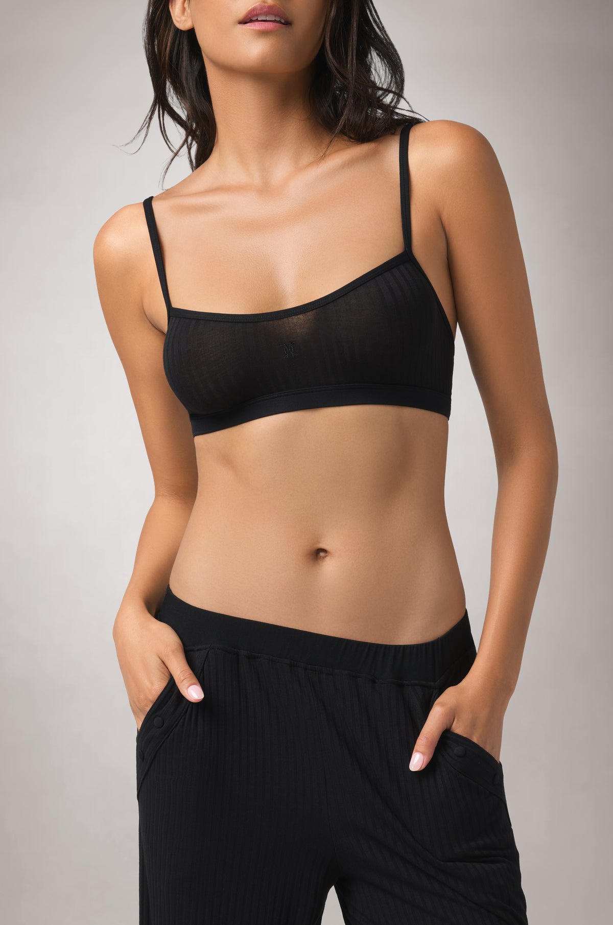 Soft rib-knit bralette with a minimal silhouette, gently shaped cups, slim adjustable straps, and subtle tonal embroidery at the center front.
