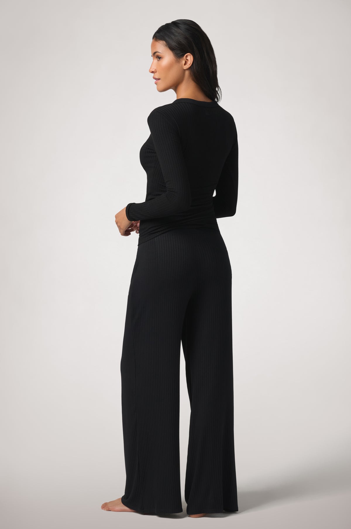 Kiki de Montparnasse Le Boy Henley top in black stretch rib knit with track pant, back.