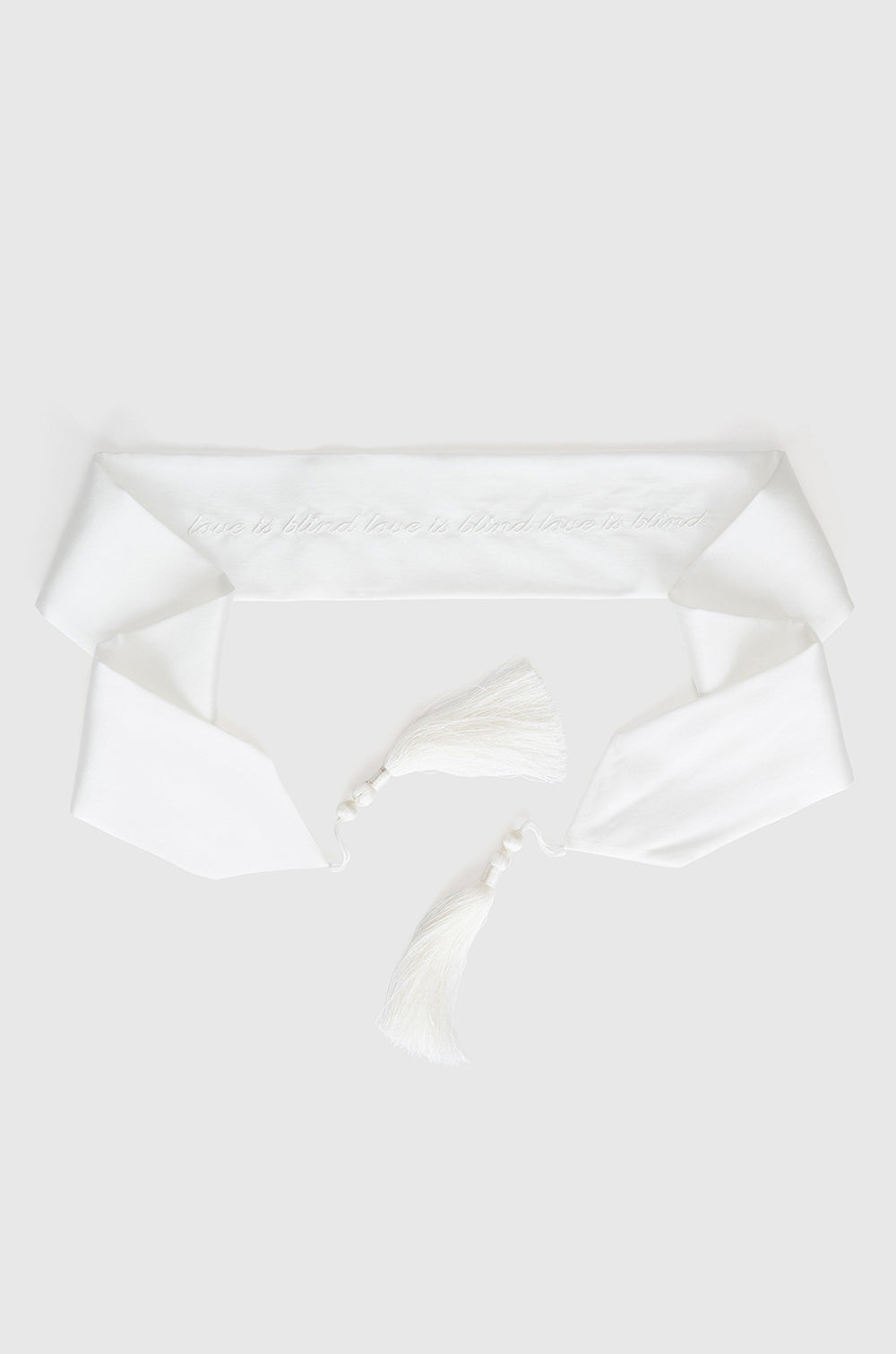 Ivory silk blindfold with white writing finished with tassels at each end