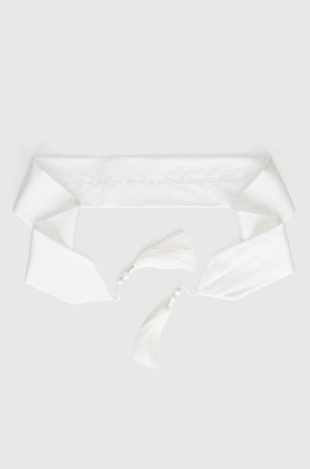 Ivory silk blindfold with white writing finished with tassels at each end
